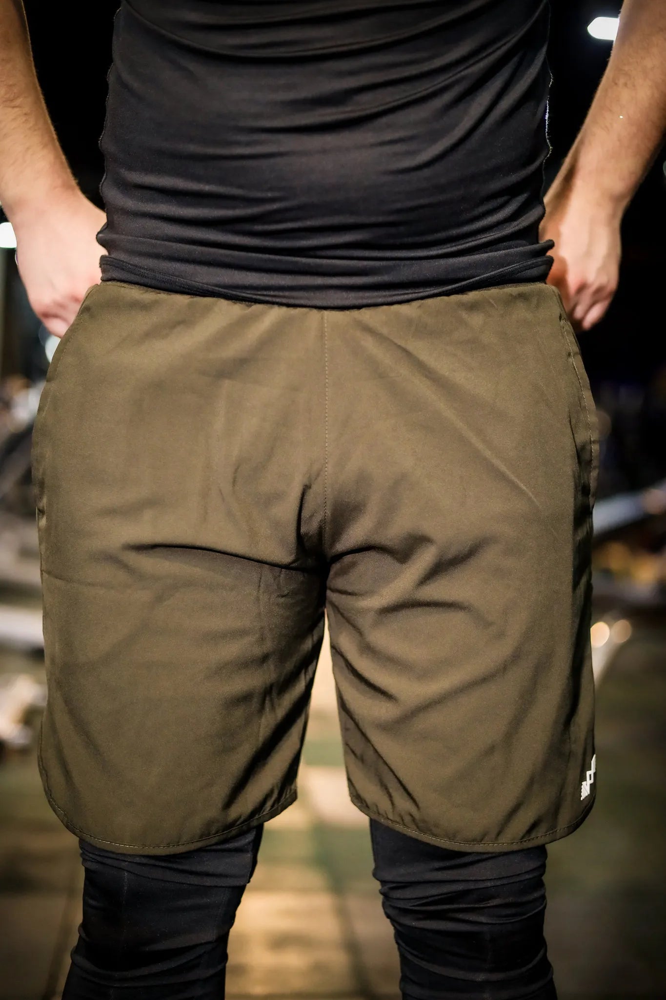 Front view of men's compression shorts in olive green, perfect for gym and outdoor activities.