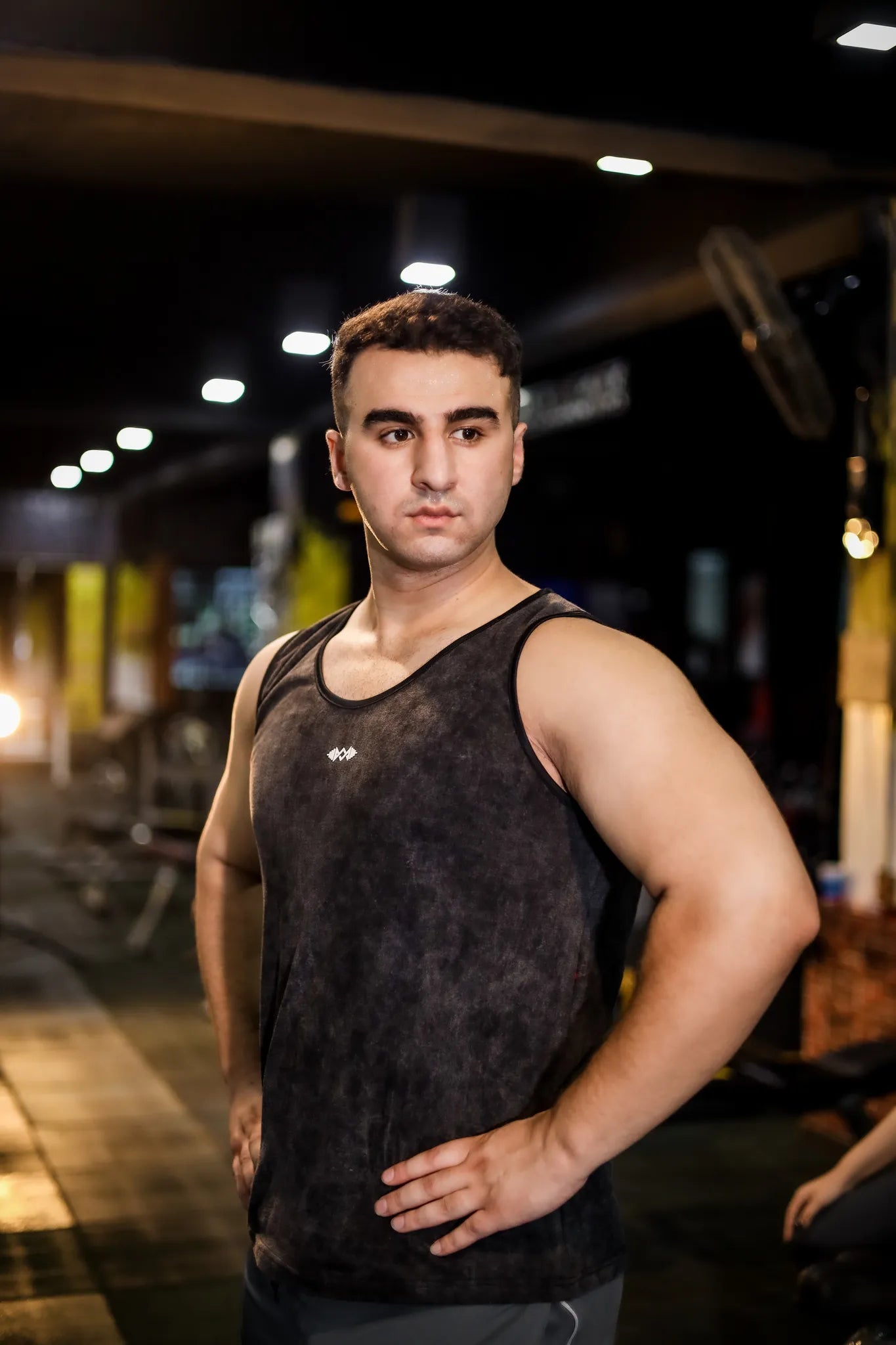 Side view of men's compression tank top in dark black, designed for flexibility and comfortable