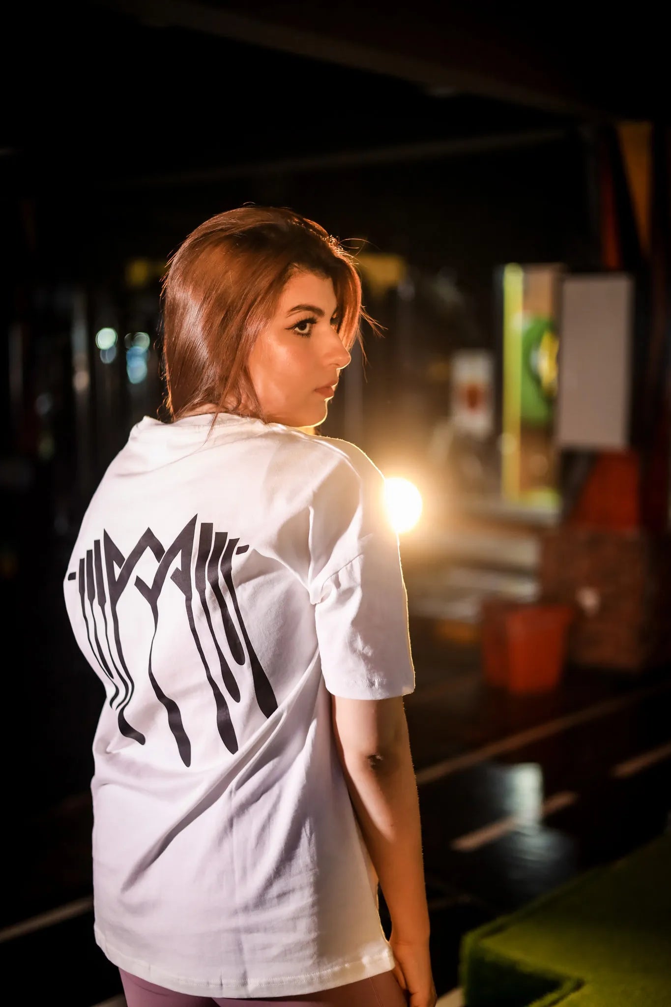 Side view of women dripping logo  shirt, showcasing comfortable fit and design